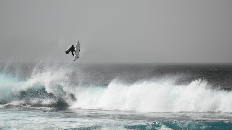Surfer jumping off a wave